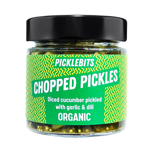 Jar of PICKLEBITS chopped pickled cucumber with a vibrant label with black lid.
