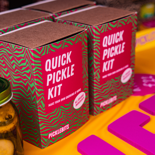 Quick Pickle Kit boxes with pink and green design on a colorful background
